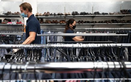 Goodwill staff move portable clothing racks