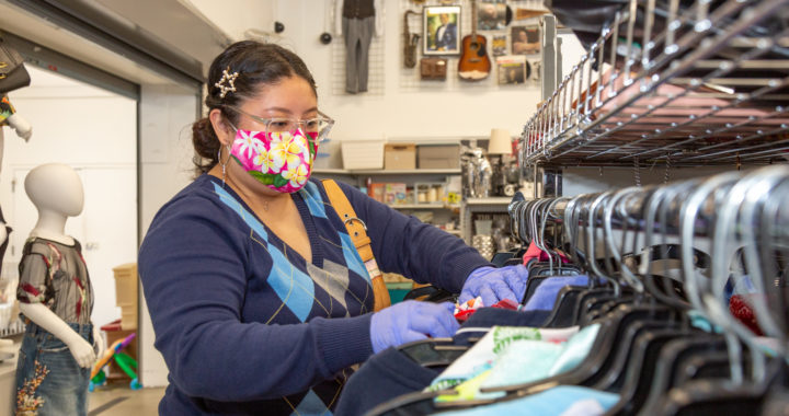 Woman shopping at Goodwill store wearing mask and gloves