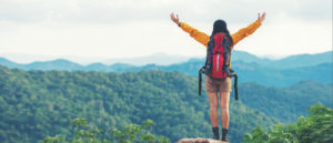 Woman hiker with raised arms