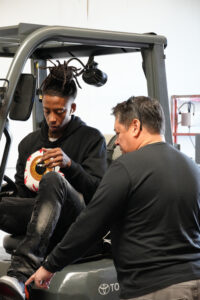 Photo of a Goodwill training program participant learning to drive a forklift.